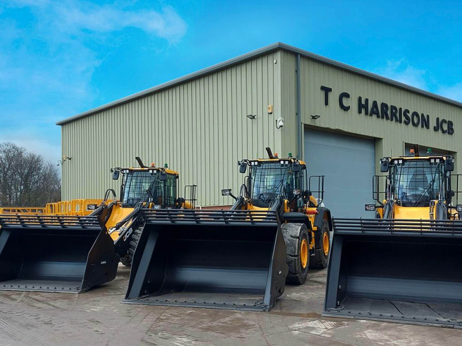 3 JCB Wastemaster wheel loaders in front of TC Harrison JCB building